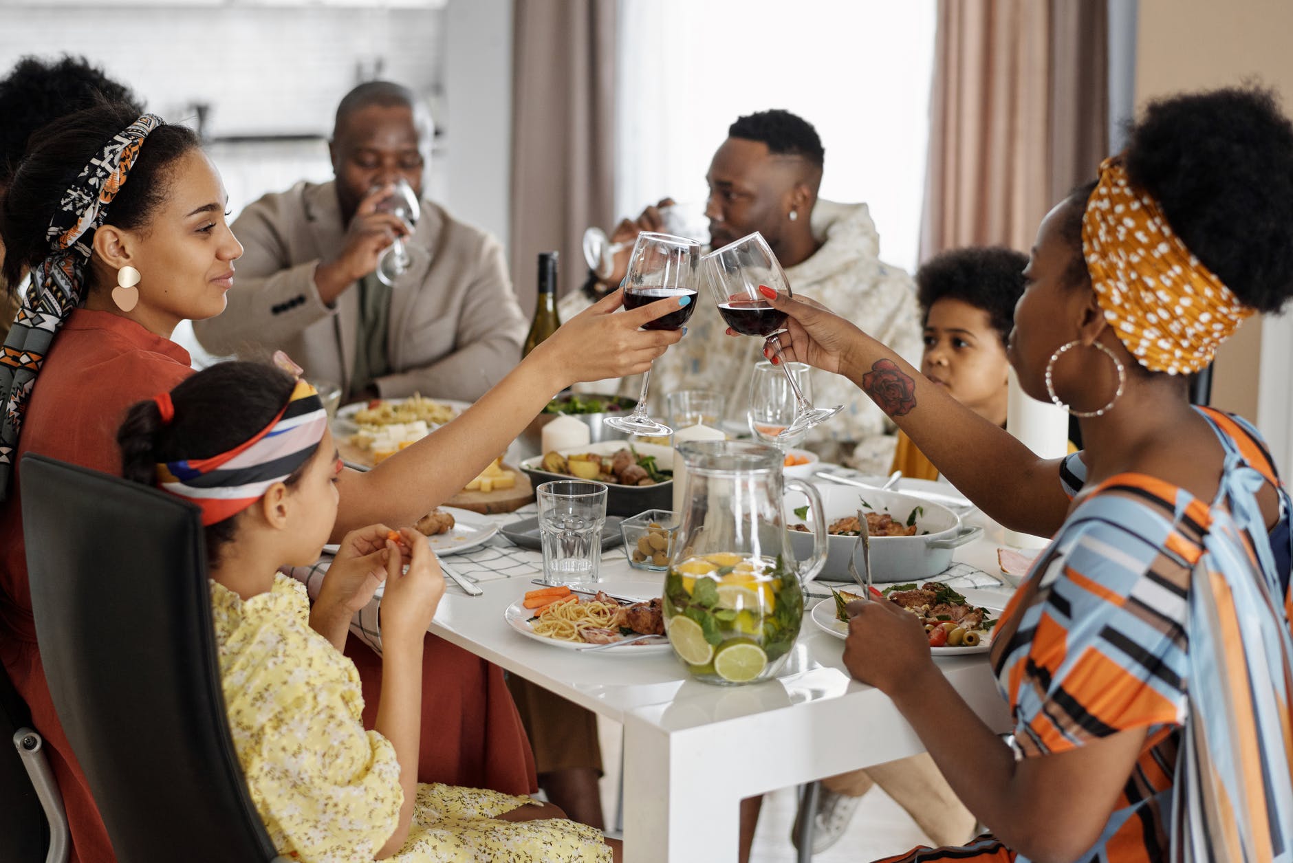 Black family at a table making a toast. 